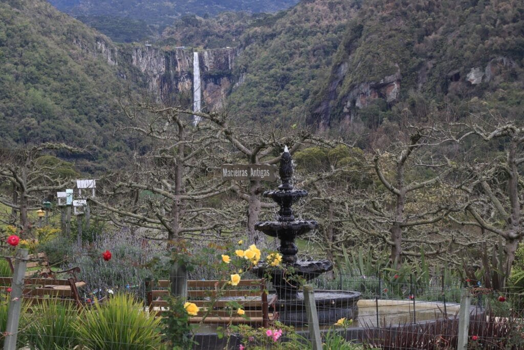 Cascata do Avencal em Urubici, com sua imponente queda d'água, cercada pela vegetação exuberante da Serra Catarinense e o vasto horizonte montanhoso.