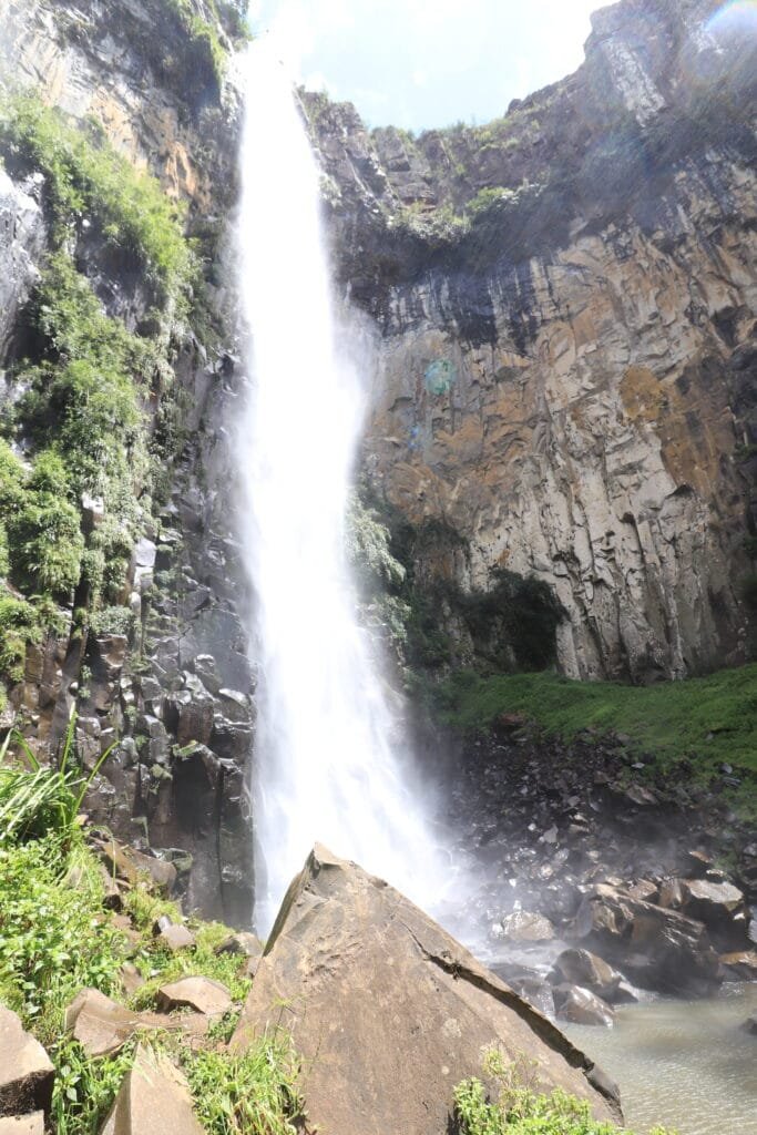 Vista de baixo para cima da Cascata do Avencal em Urubici, mostrando a força da água e a beleza da serra.